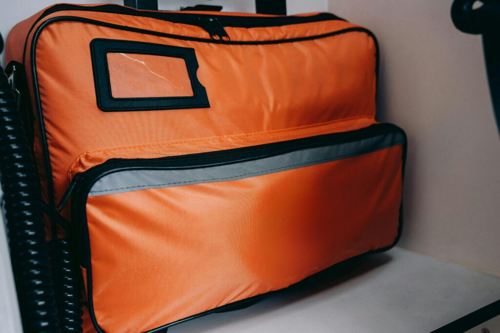 pexels photo 27914830 27914830 Close-up of an orange emergency medical bag with visible zippers and compartments.